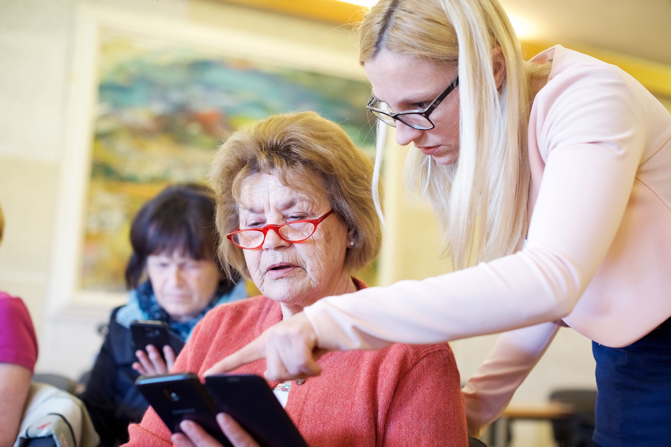 Young woman explaining something to a pensioner